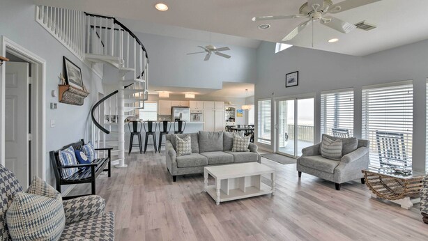 A spacious living room with a staircase, a dining area, and a kitchen. - Beachside Living: Family Retreat in Galveston (Galveston)