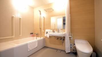 A modern bathroom with a bathtub, sink, and toilet. There are handrails, a showerhead, and a towel hanging on the wall.