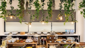 A buffet with various food items and utensils, including bowls of salad, pasta, and other dishes, arranged on wooden tables. - Green Rich Hotel Tottori Ekimae Artificial Hot Spring Futamata Yunohana (Tottori)
