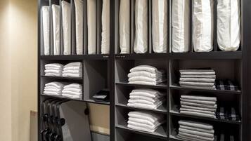 A neatly organized storage unit with shelves holding folded towels and linens.