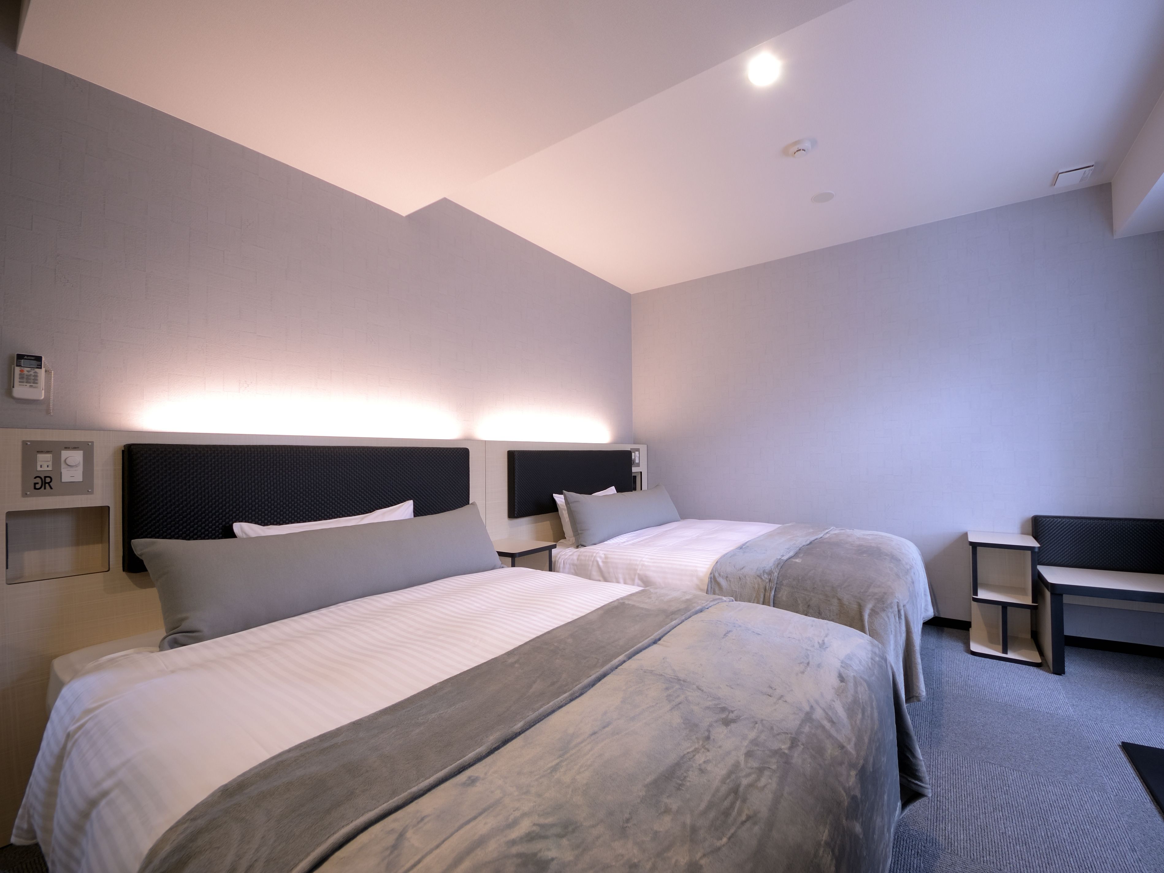 Una habitación de hotel con dos camas, un escritorio y una silla.