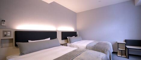 Una habitación de hotel con dos camas, un escritorio y una silla.