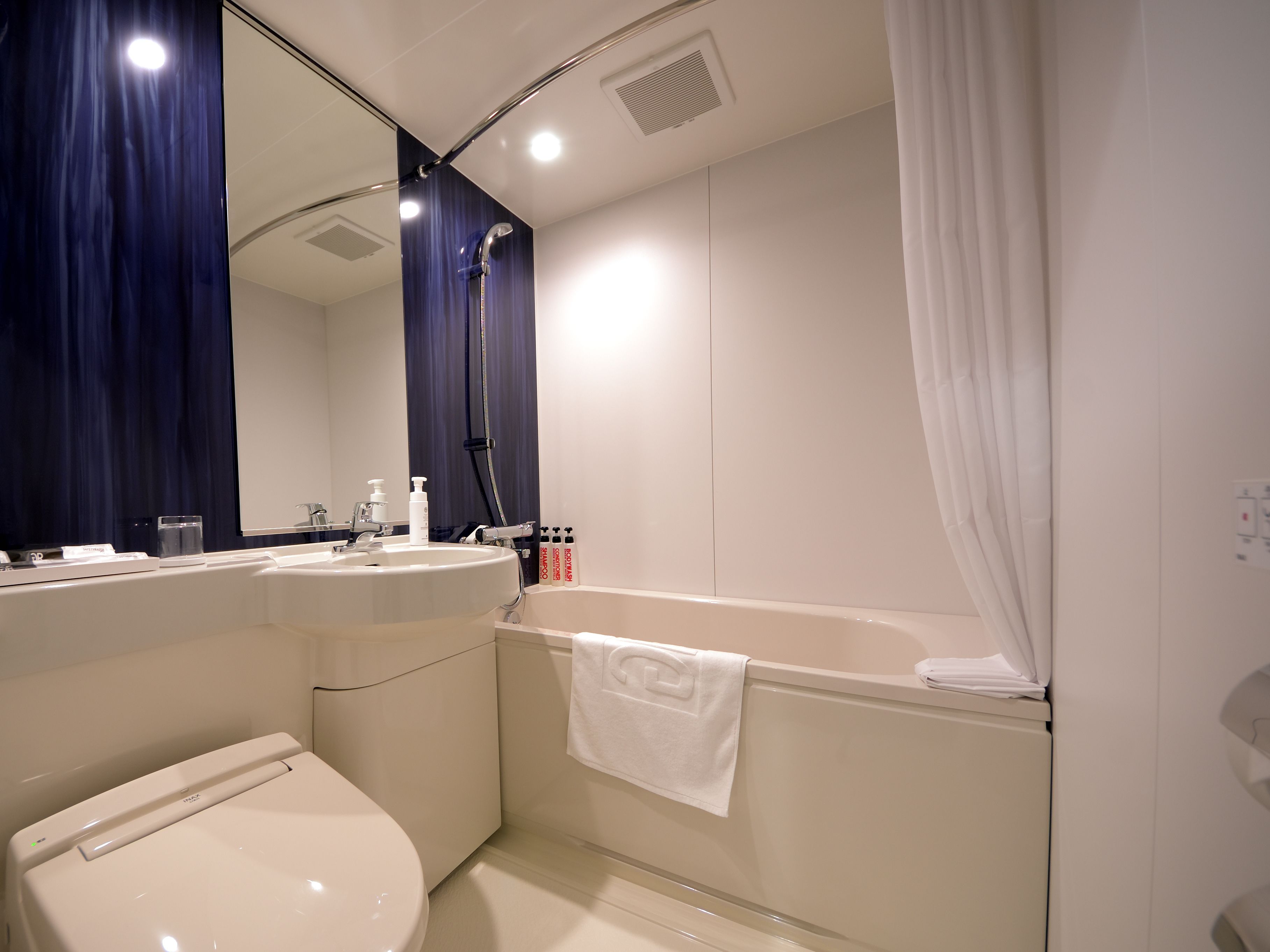 A modern bathroom with a toilet, sink, and bathtub.