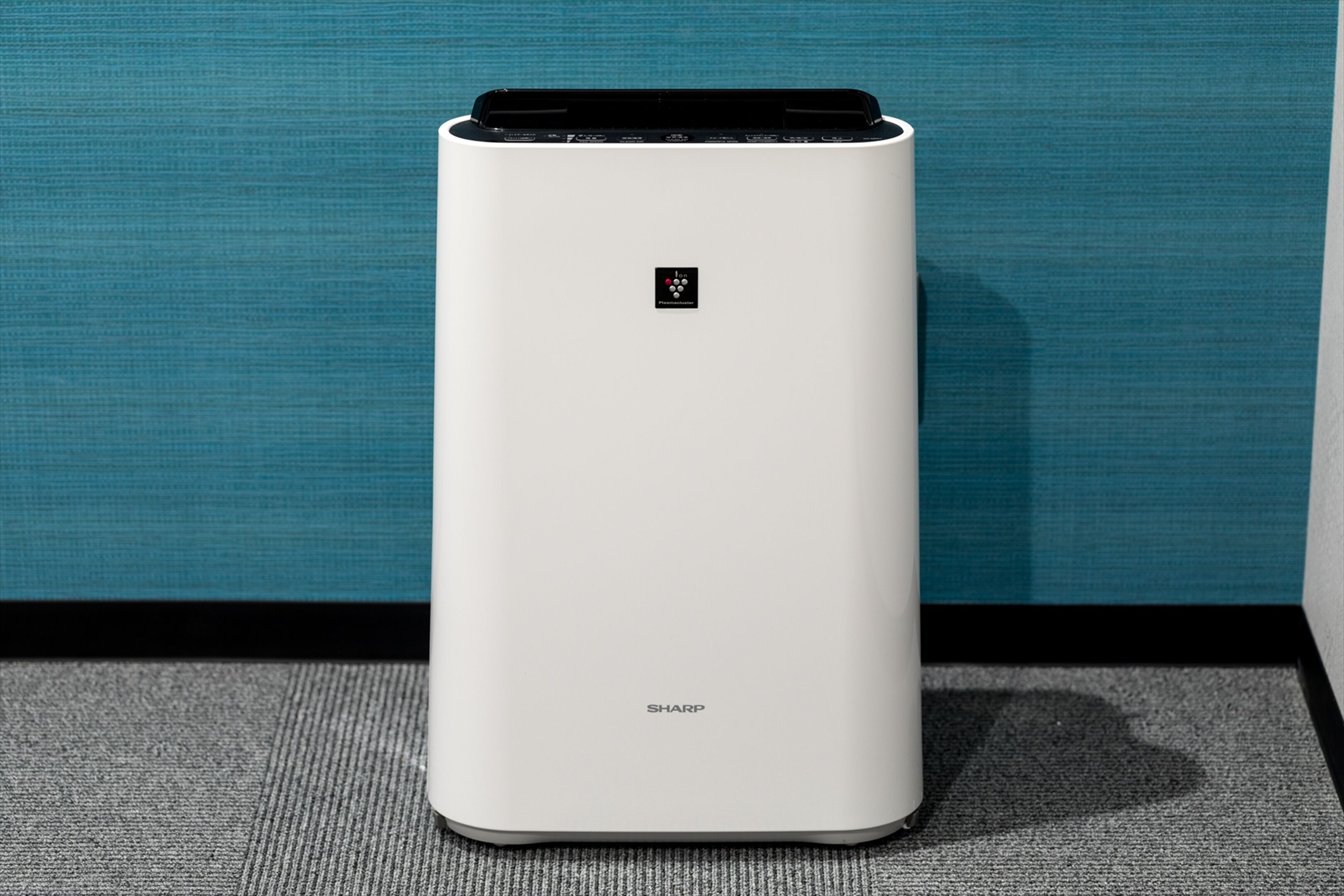A white, modern air purifier with a control panel and the brand name 'SHARP' visible on the front.
