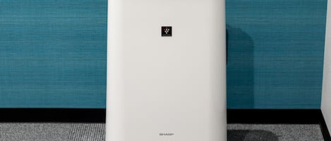 A white, modern air purifier with a control panel and the brand name 'SHARP' visible on the front.