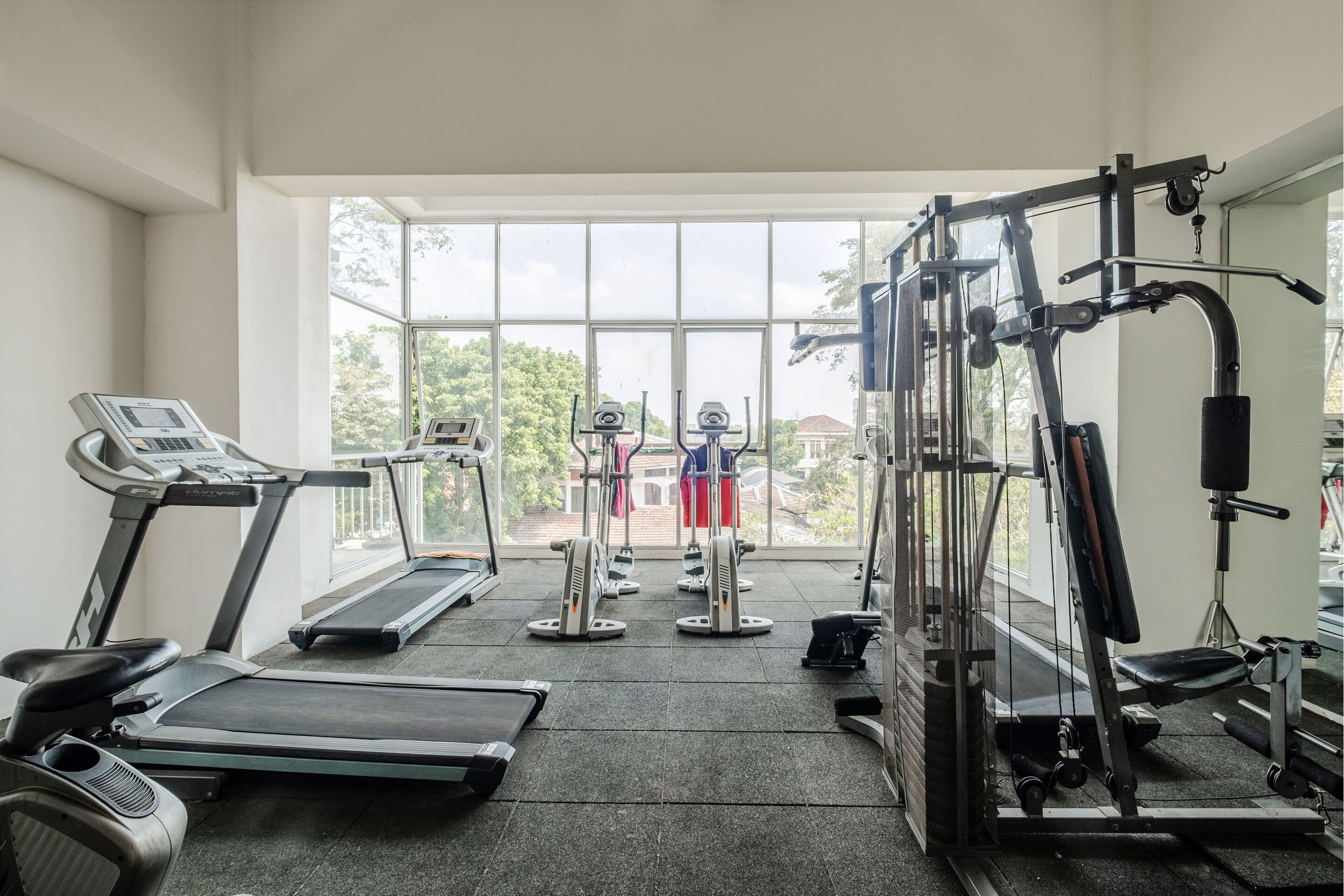 Un gimnasio con cintas de correr, elípticas y equipos de levantamiento de pesas.