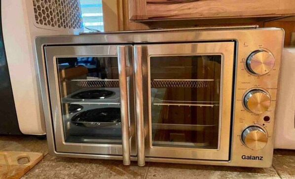 Un four grille-pain Galanz doté de deux portes en acier inoxydable et d’un panneau de commande avec trois boutons.