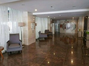 Relax in the stylish lobby with a comfortable armchair and sofa, surrounded by art and natural light.