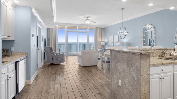 A spacious kitchen with a large island, a dining area with a view, and a balcony with a view. - Direct Beachfront Lazy River Waterslide-Hot tub-Indoor Pool-Walk to restaurants (Orange Beach)