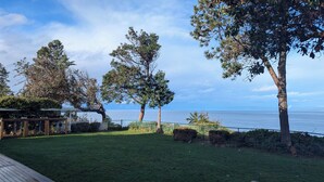 Un espacio al aire libre con césped, árboles y vista al mar.