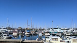 Marina con varios barcos amarrados, incluyendo veleros y lanchas.