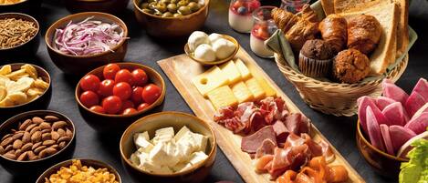 Diversos tipos de comida, como queso, embutidos y pan.