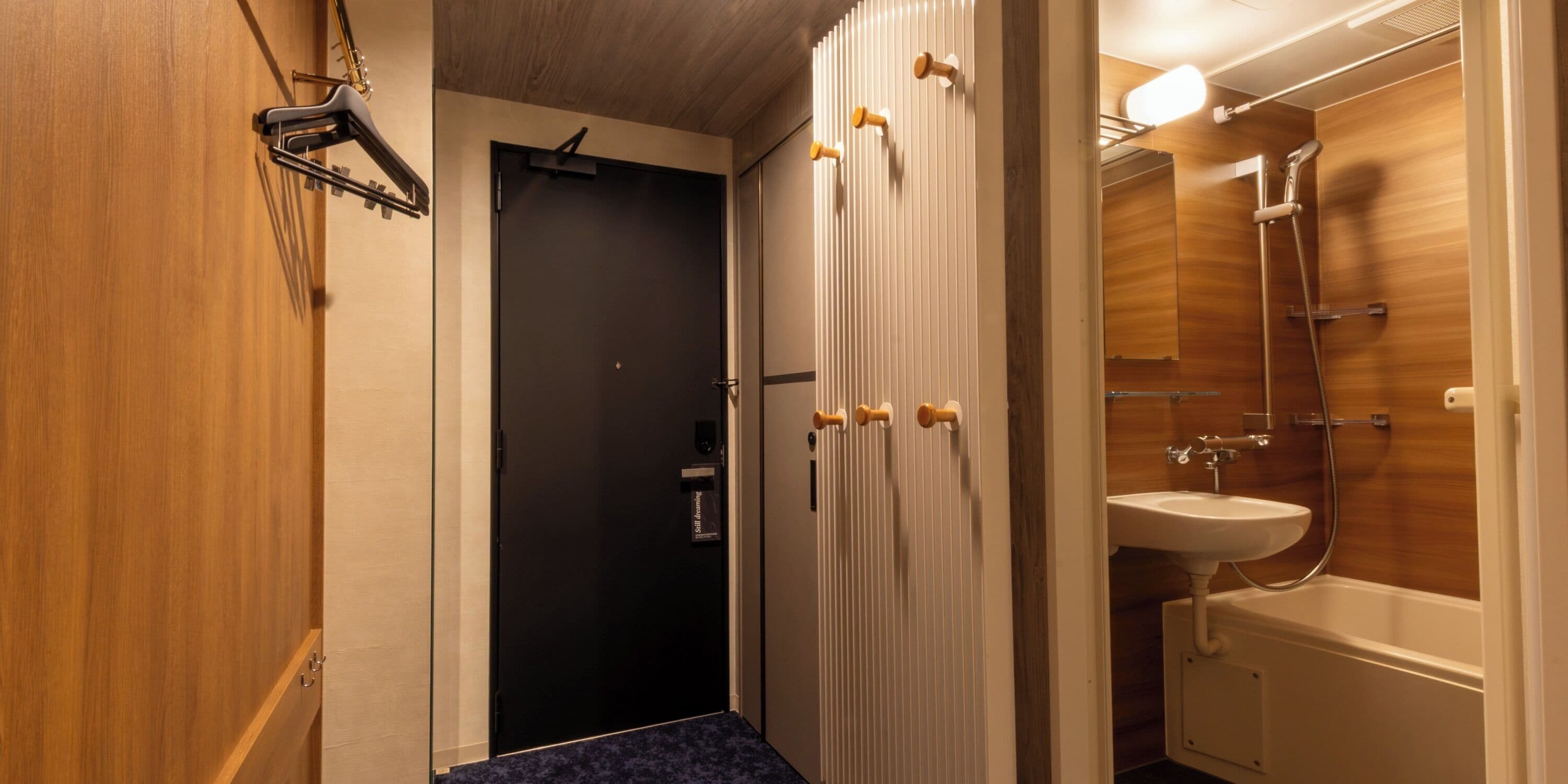 Ein modernes Badezimmer mit Dusche, Waschbecken und einer Tür mit Handtuchhalter.