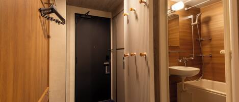 A modern bathroom with a shower, a sink, and a door with a towel rack.