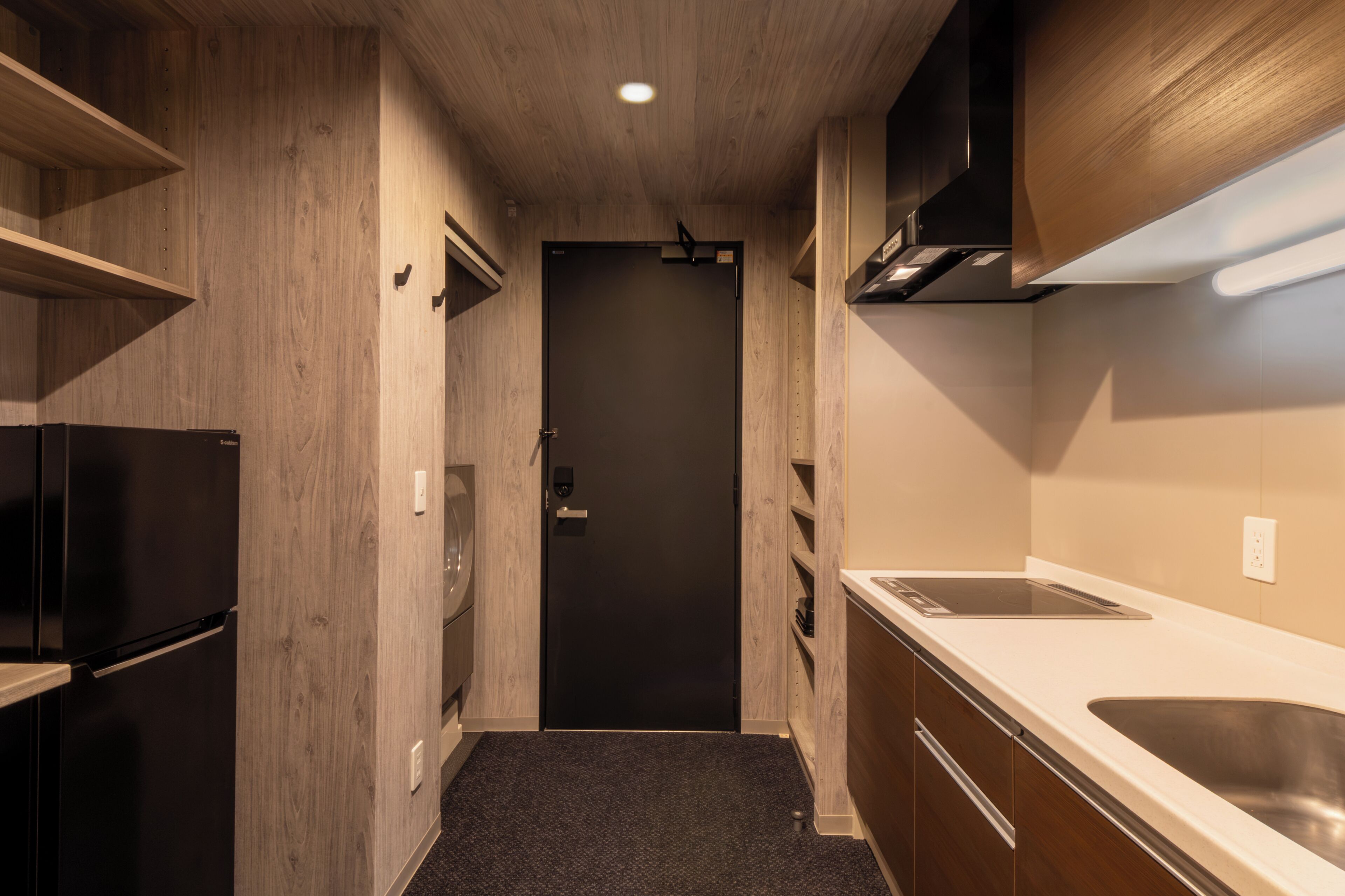 A compact kitchen with a refrigerator, stove, and sink.