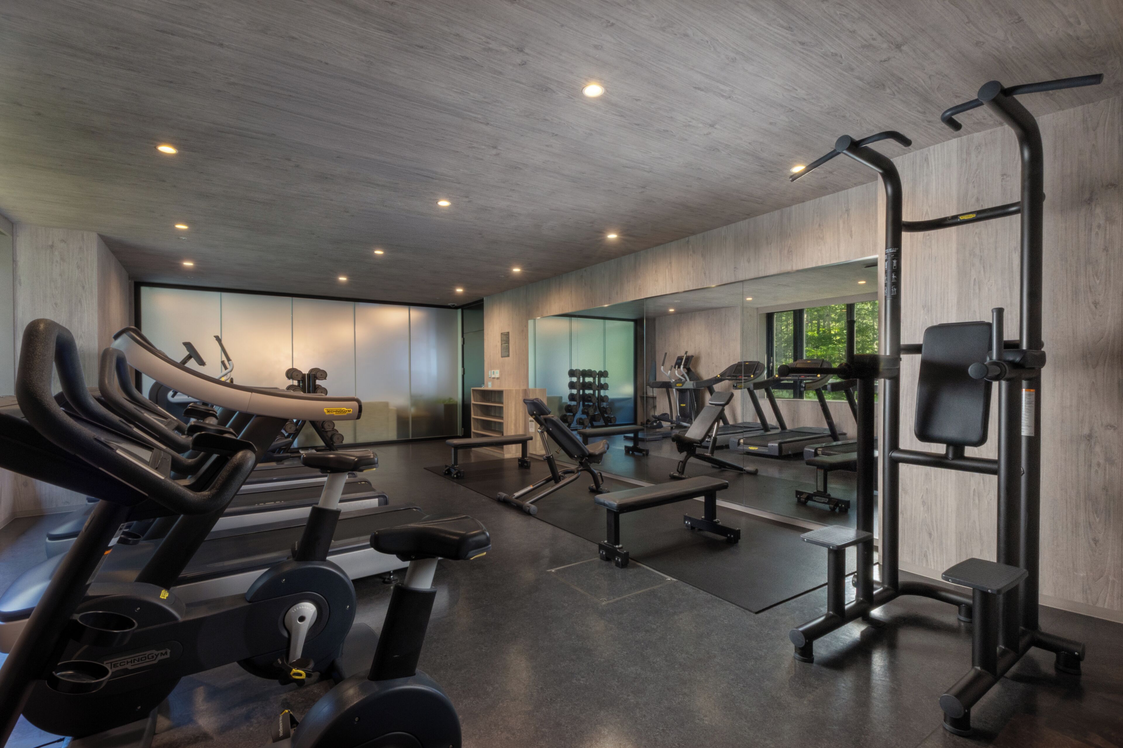 Uma academia moderna com diversos equipamentos de exercício, incluindo esteiras, aparelhos de musculação e pesos livres.