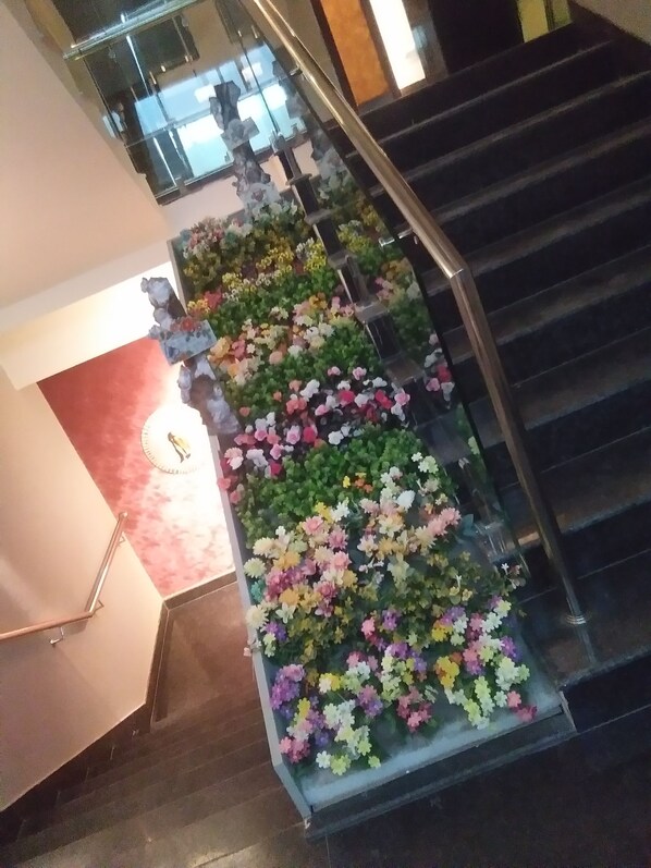 A staircase with a floral arrangement along the handrail.