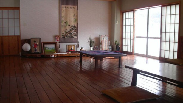Una habitación japonesa tradicional con suelo de tatami, una mesa baja y un panel de shoji.