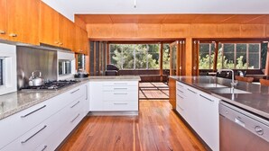 Una cocina moderna con armarios de madera, electrodomésticos de acero inoxidable y un ventanal con vistas al exterior.