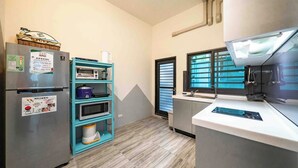 Eine kleine Küche mit Kühlschrank, Mikrowelle und Backofen.