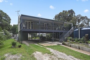 A two-story building with a covered outdoor area and a staircase leading to the upper floor.