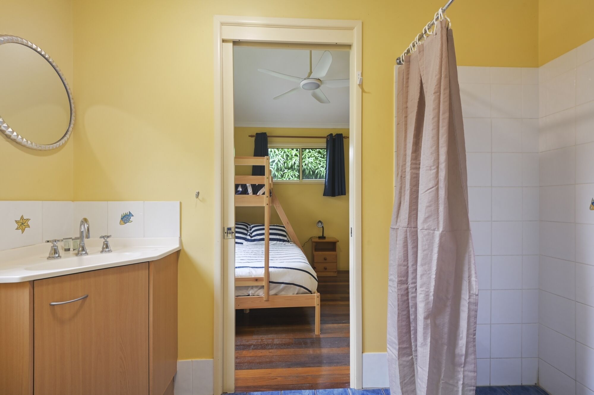 A bathroom with a sink, mirror, and shower curtain.