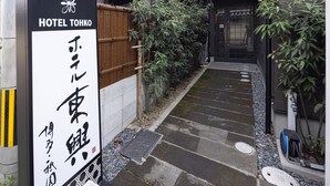 Un camino que lleva a un edificio con un letrero que dice Hotel Tohko.