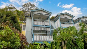 A multi-story building with balconies, surrounded by lush greenery. - Villa at Tangalooma - Villa 14 (Moreton Island)
