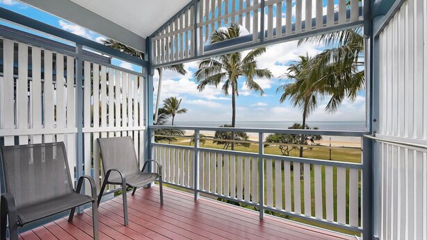 A covered balcony with a view of the beach and palm trees. - Villa at Tangalooma - Villa 14 (Moreton Island)