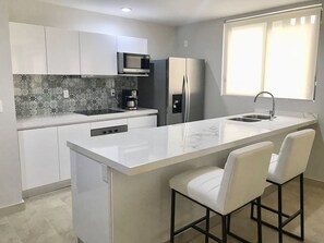 Fridge, microwave, coffee/tea maker, cookware/dishes/utensils