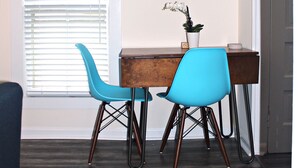 A room with a wooden desk, two blue chairs, a mirror, and a potted plant. - Stylish Ocean Grove Apt - 4 Blocks from Beach & 2 Blocks from Downtown Asbury (Ocean Grove)