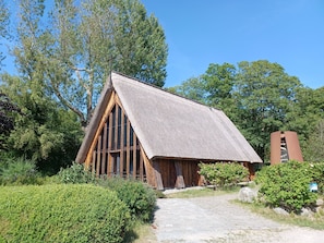 A rustic building with a steeply pitched roof, wooden framing, and a thatched roof. - Vacation apartment Frida, Germany (Ahrenshoop)