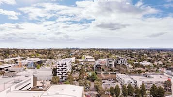A cityscape with modern buildings, a parking lot, and a distant skyline.