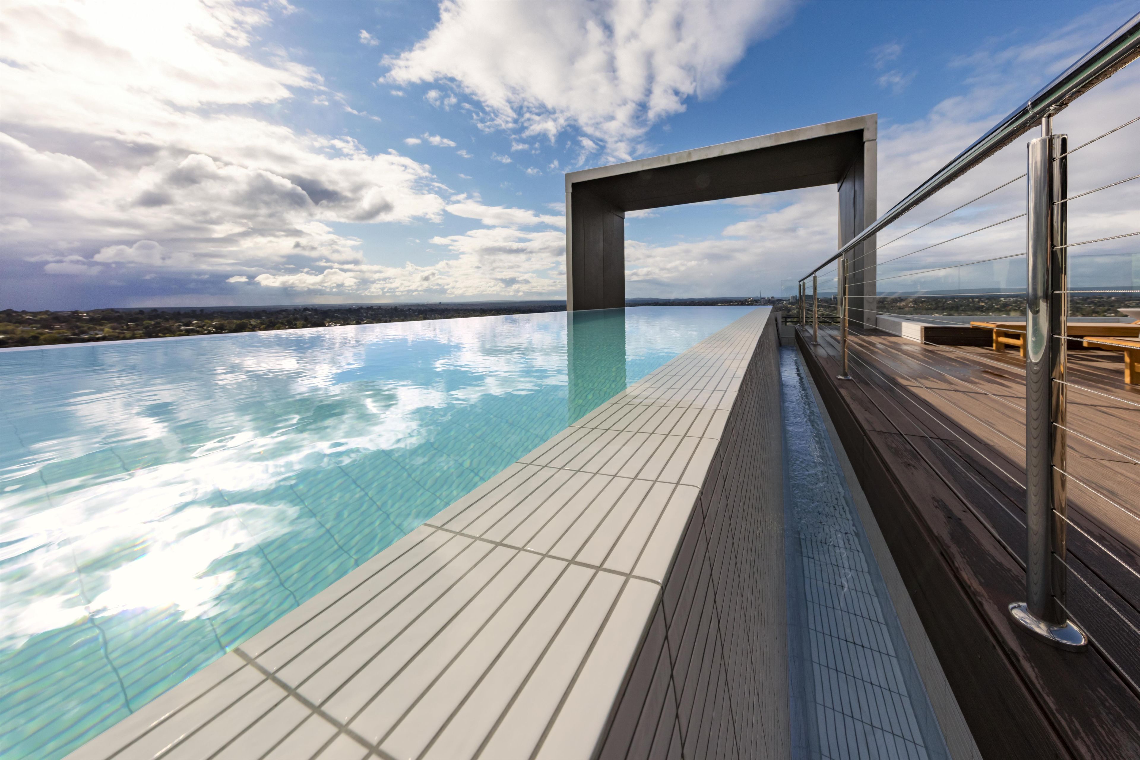 A rooftop infinity pool with a clear view of the city skyline.
