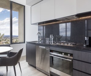 A modern kitchen with a large window, stainless steel appliances, and a minimalist design. - Avani Melbourne Box Hill Residences (Box Hill)