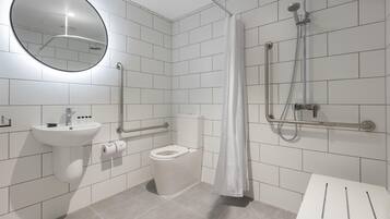 A modern bathroom with a toilet, sink, and shower.