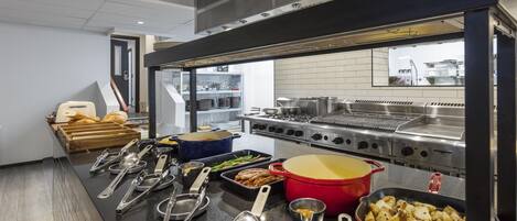 A buffet setup with various food items and cooking utensils.
