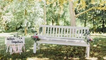 A white bench with a sign that reads "Better together" and a small bouquet of flowers.