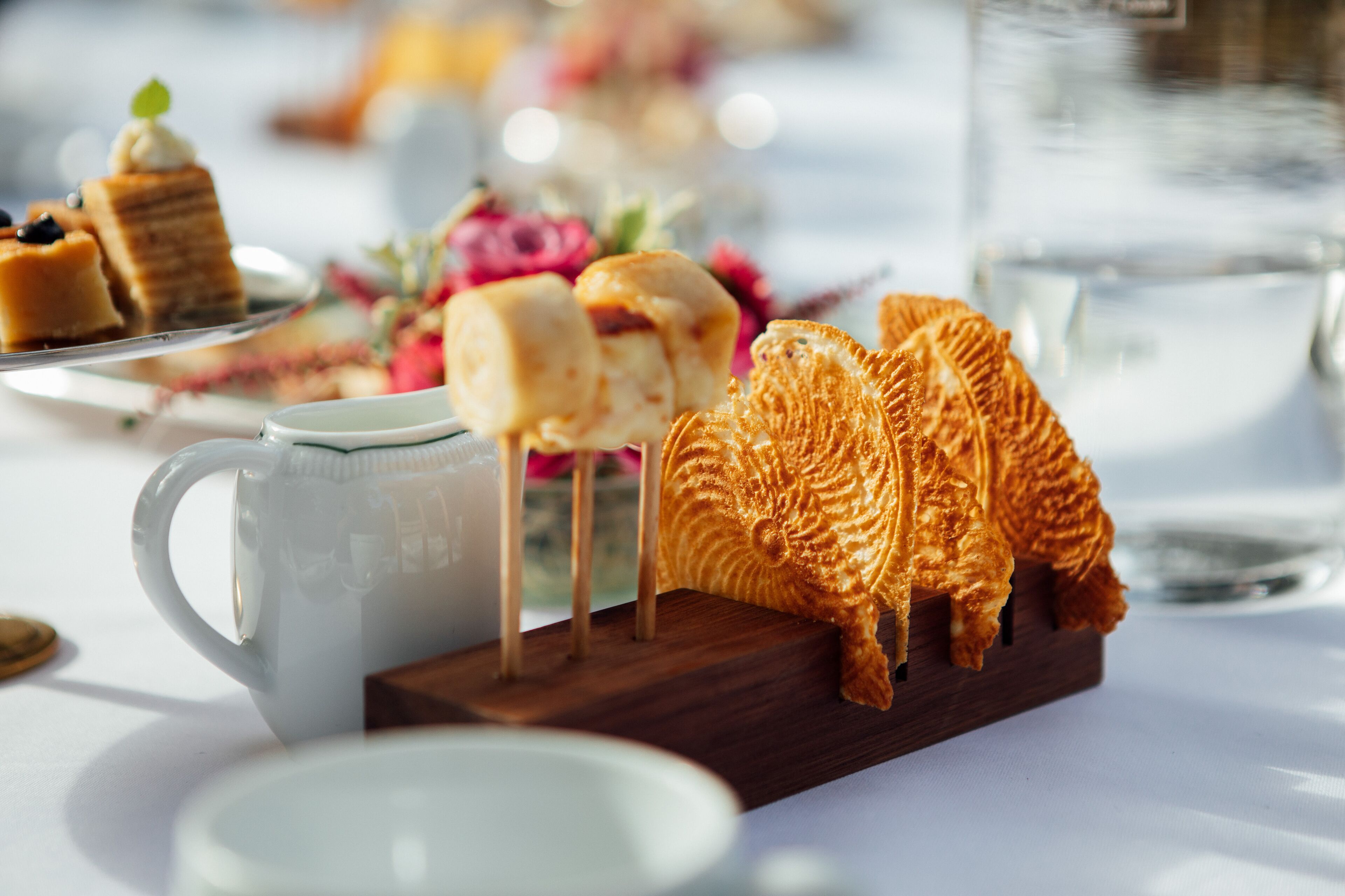 A table with pastries, a mug, and a glass of water.
