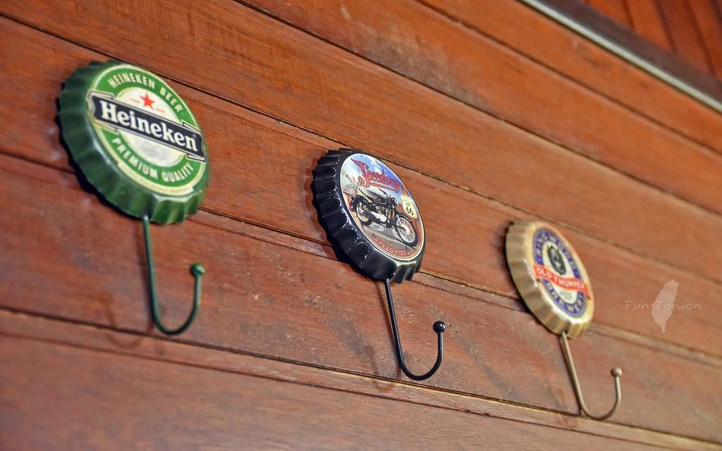Tres tapones de botellas de cerveza sujetos a una pared de madera.