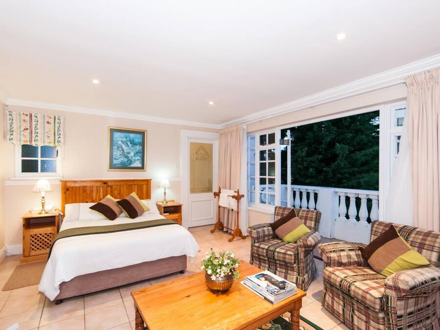 A bedroom with a bed, bedside tables, a nightstand, a wooden coffee table, and a window with curtains.