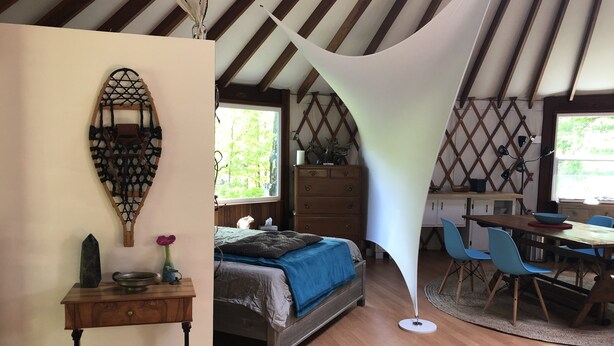 A bedroom with a bed, dresser, desk, and chairs. - Totally secluded Yurt surrounded by waterfalls, brooks, cliffs and forest (Ulster Park)