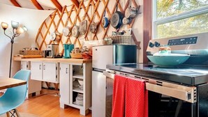 A compact kitchen with a wooden lattice wall, white cabinets, and a stainless steel stove. - Totally secluded Yurt surrounded by waterfalls, brooks, cliffs and forest (Ulster Park)