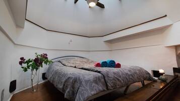 Cozy retreat with a single bed, bedside table, and vase with flowers.