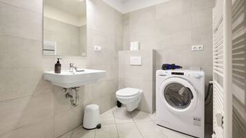 Ein modernes Badezimmer mit Waschbecken, Toilette und Waschmaschine.