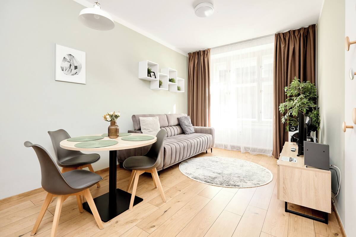Una sala de estar moderna con una mesa de comedor, sofá y un escritorio pequeño.