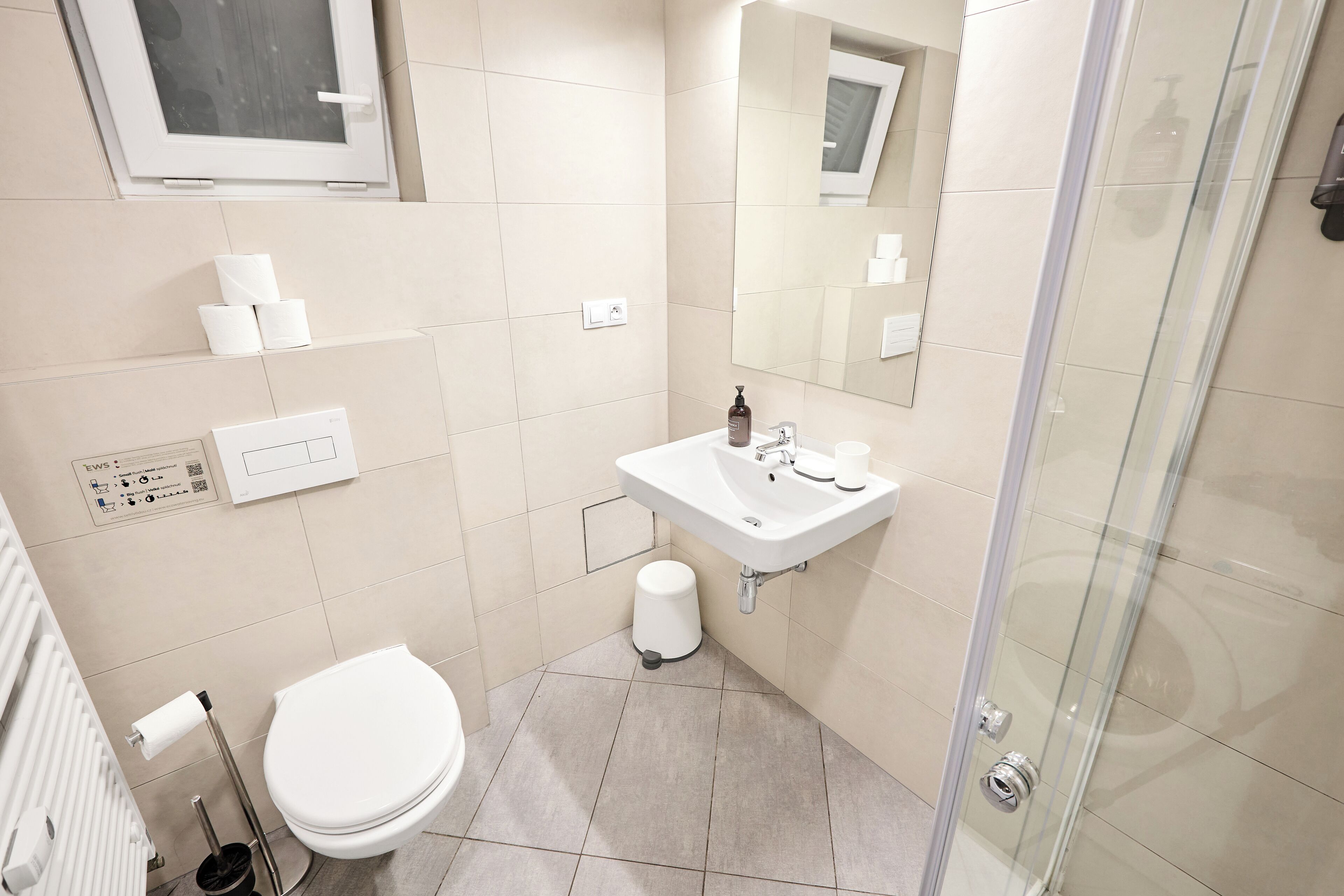 A modern bathroom with a toilet, sink, and shower.