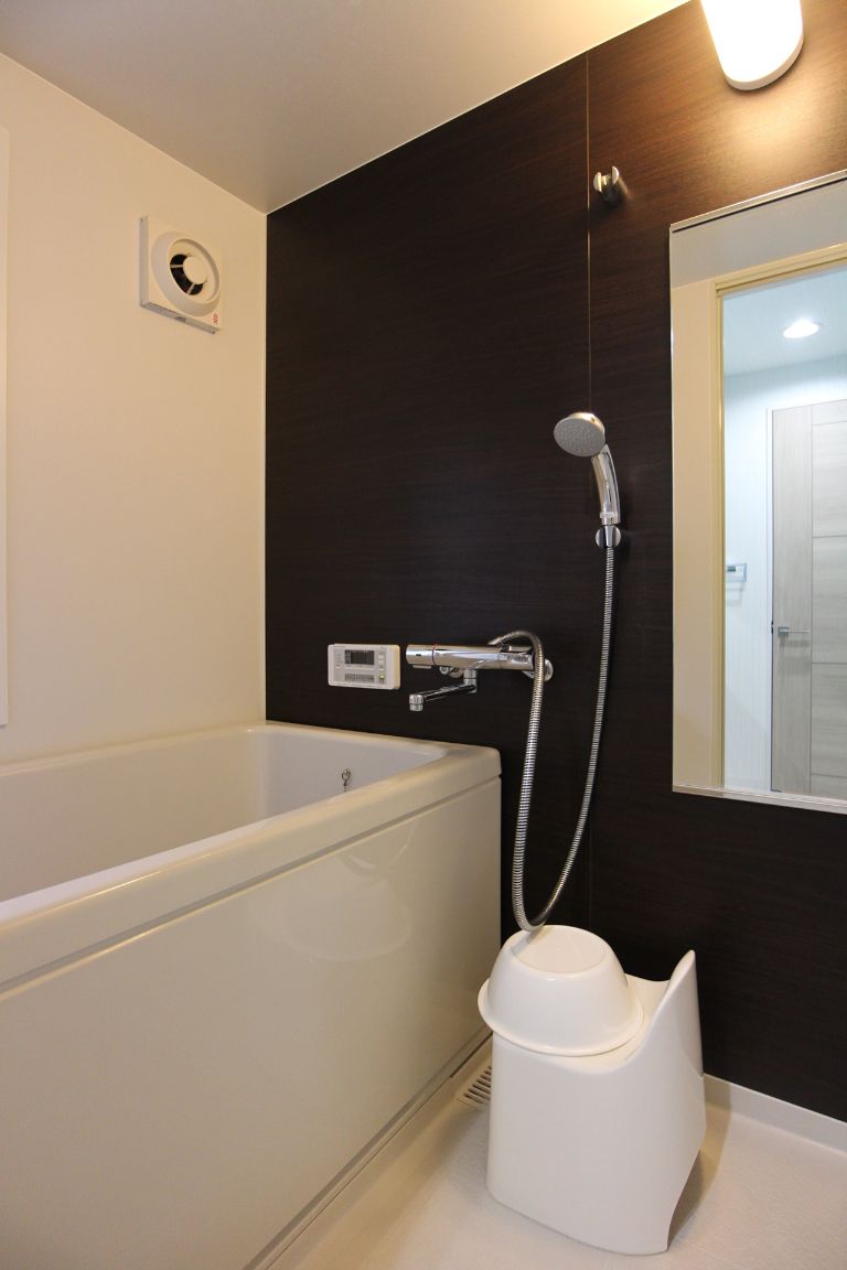 A modern bathroom with a bathtub, a showerhead, and a toilet.