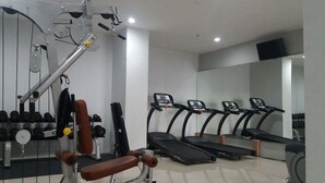 Een sportschool met krachtapparaten, loopbanden en gewichten.