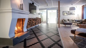A modern living room with a fireplace, a sofa set, and a patterned floor. - Hotel Akerlund (Jokkmokk)